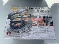 Front of sealed box showing Hamilton Beach double breakfast sandwich maker image and model 25490C