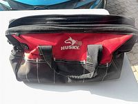 Front view of Husky red and black soft tool bag showing logo, handles, exterior pockets