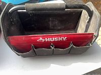 Top view showing open interior, red Husky-branded divider, exterior pockets