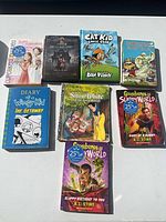 Eight of the nine books laid out on a table