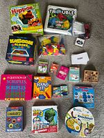 Overview of all boxed games, card decks, puzzles and loose components on floor
