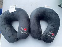 Front view of both dark grey embroidered U-shaped neck pillows