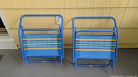Two folded blue striped beach chairs side by side
