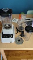 All components laid out: base, blender jar, food-processor bowl, cup, blades, manuals