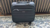 Front view of black Bermas rolling carry-on suitcase showing exterior and wheels