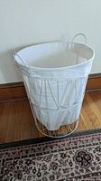 Full view of white steel wire frame hamper with canvas liner