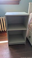 Front view of white Ikea Gursken nightstand with two shelves