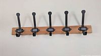 Full view of IKEA Kartotek wall rack showing all five hooks mounted on pine base