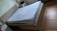 Bed frame with mattress showing overall condition and storage drawers