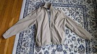 Front view of beige Ralph Lauren Polo Golf jacket laid flat