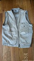 Front view of khaki REI vest showing pockets and zipper