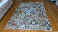 Full view of Surya Harput rectangular floral rug placed on hardwood floor