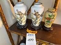 Front view of three vases on stands