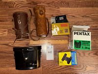 Group shot showing all cases and boxed binoculars with ruler for scale