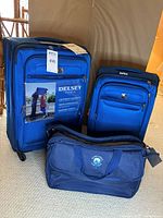 Front view of all three blue Delsey luggage pieces