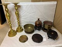Group shot of all brass pieces, pottery vase, and wooden stands