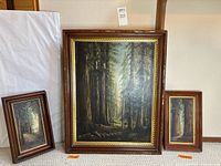 Three framed forest paintings grouped together for size comparison