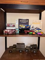 Shelf view with books, die-cast cars, train cars