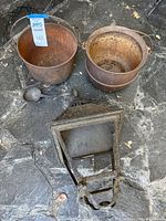 Overview showing two cast iron cauldrons, lantern cover, mini skillet