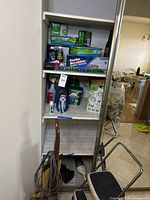 Shelf with cleaning supplies, Shark WandVac, LED bulbs, showing quantity