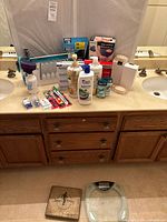 Full lot displayed on bathroom counter with toiletries, massager, exerciser board and scale