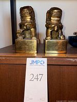 Front view of both brass Foo Dog bookends on shelf