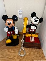 Both Mickey Mouse figural telephones side by side showing handset and keypad details