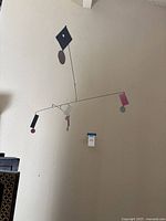 Full view of metal mobile hanging against wall