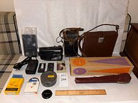 All items overview: camera, camcorder, cases, film can, paper, tapes, filter, lens cap