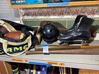 Wide view of lot: Camel duffle bag with footballs, bowling ball, roller skates, bats