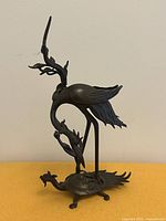 Front view of bronze crane standing on turtle