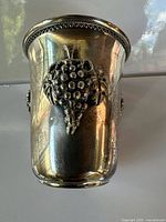 Front view showing applied grape cluster and beaded rim