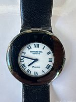 Front view of Raymond Weil Phantom watch showing dial, hands, Roman numerals, case and strap texture