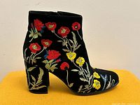 Left profile of single boot showing floral embroidery and block heel
