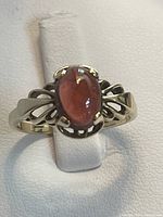 Front view of 10K yellow gold ring with oval garnet cabochon