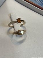 Citrine ring and child’s signet ring side by side on display pad
