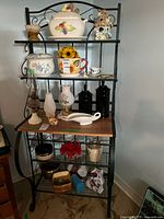 Full view of bakers rack showing metal frame, wood shelf, upper rack sections