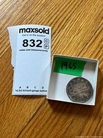 Coin in small box beside lot card highlighting year