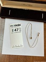 Full lot view showing chain, pendant, and scale reference card