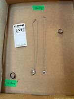 Full lot showing two rings and two necklaces inside box