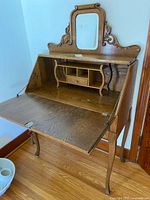 Desk with fall front open showing interior cubbies, mirror and writing surface