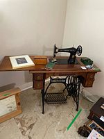 Entire sewing machine mounted in cabinet with leaf extended, drawers visible