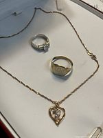 Overview of the three jewellery pieces: chain with pendant, sterling ring, and gold signet ring