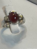 Front view showing garnet cabochon, gold flanks, silver band