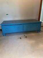 Front view of blue lowboy cabinet showing two drawers and overall form