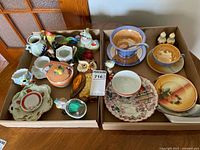 Overview of both trays showing mixed ceramic and porcelain pieces