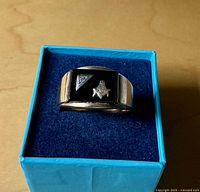 Top view of yellow gold ring with black onyx, white-gold triangle and diamond, Masonic emblem