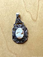 Front view of sterling cameo pendant on wood background