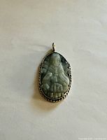 Front view of carved jade Quan Yin pendant in sterling bezel