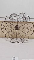 Full view of metal scrollwork wall decor against wall